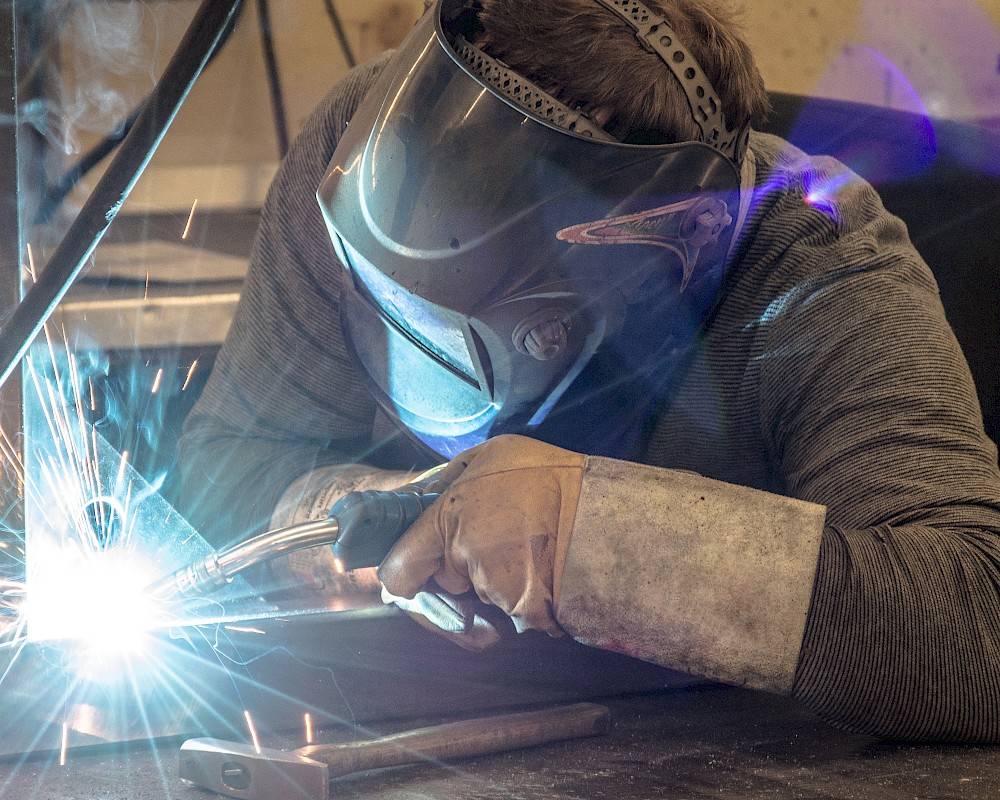A laborer of Deman at work with a welding machine