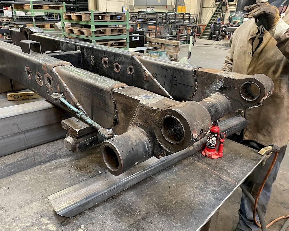 welder starts repair or maintenance of machine part on workbench in workshop