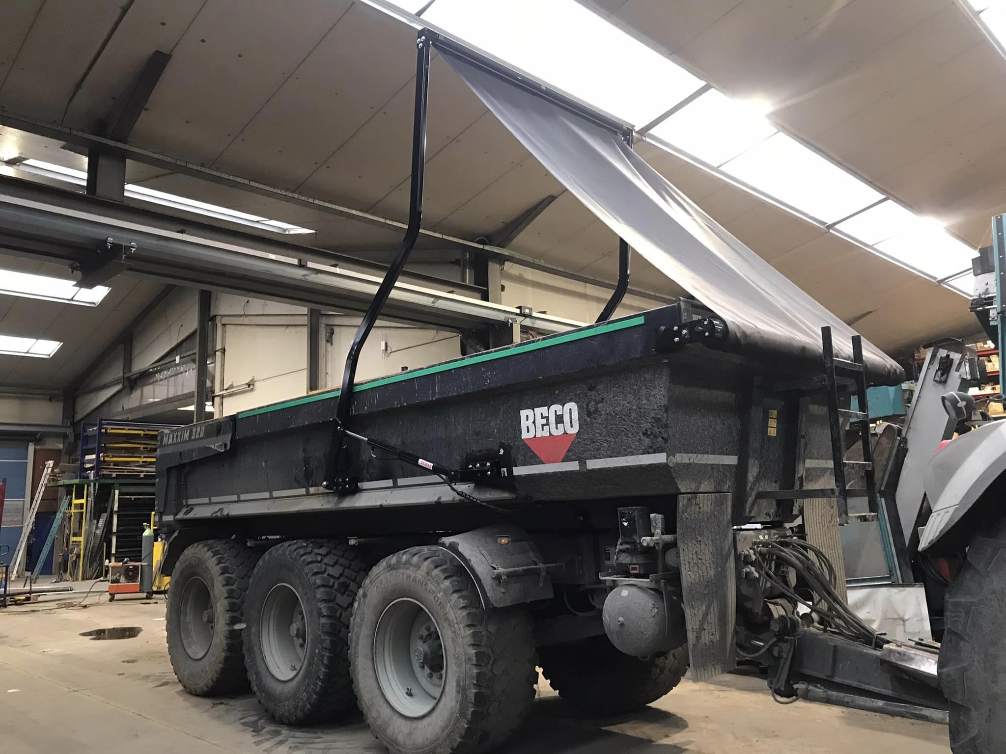 Deman hydraulic arms system puts cover roll over green loading bay in shed