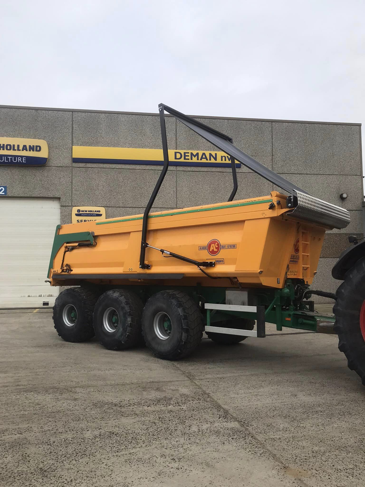 Deman hydraulic arm system puts cover roll over yellow cargo box