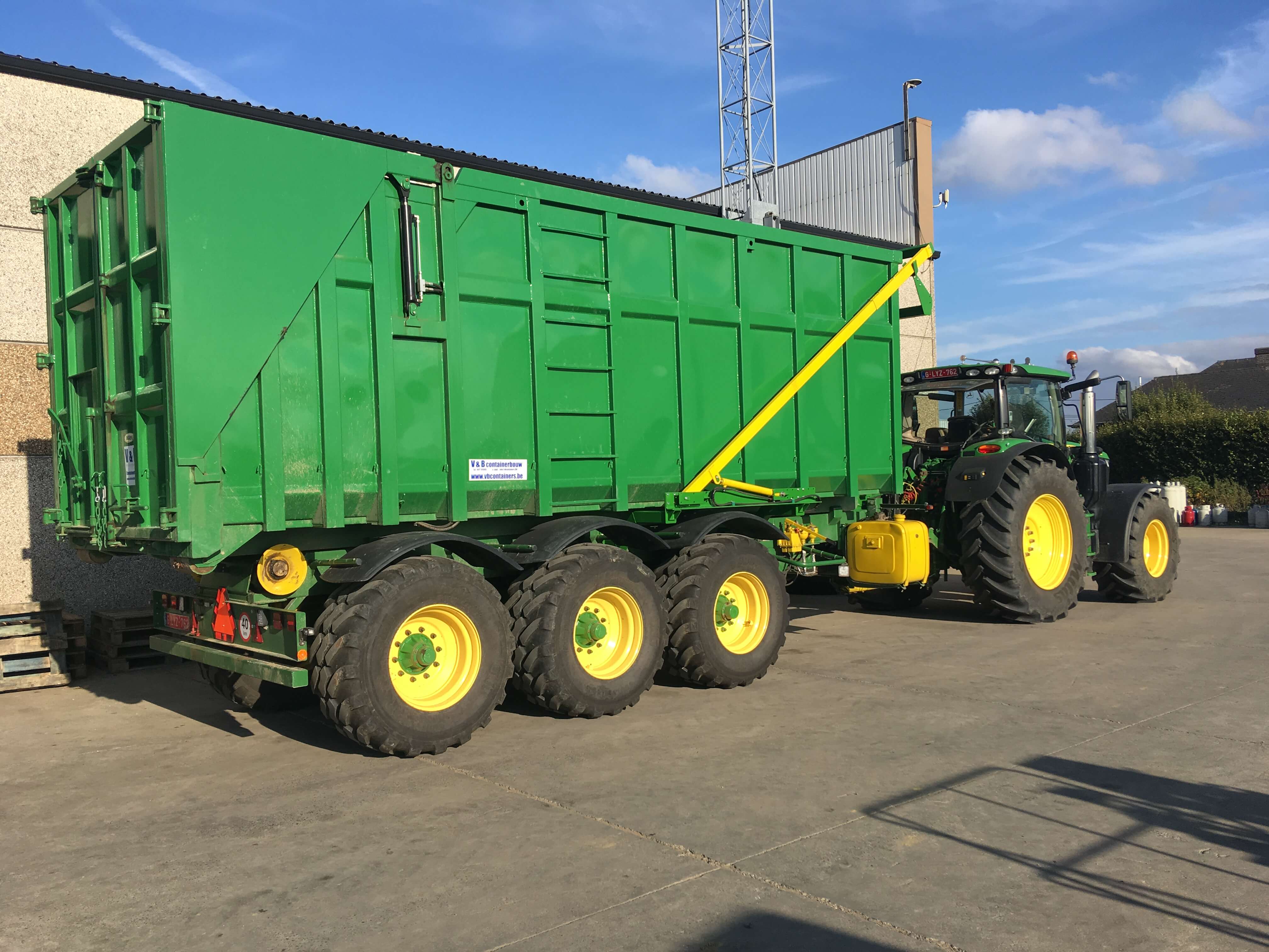 large green cargo box attached to tractor
