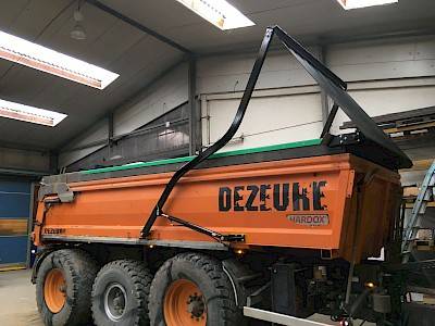 Deman hydraulic arms system puts cover roll over orange cargo box