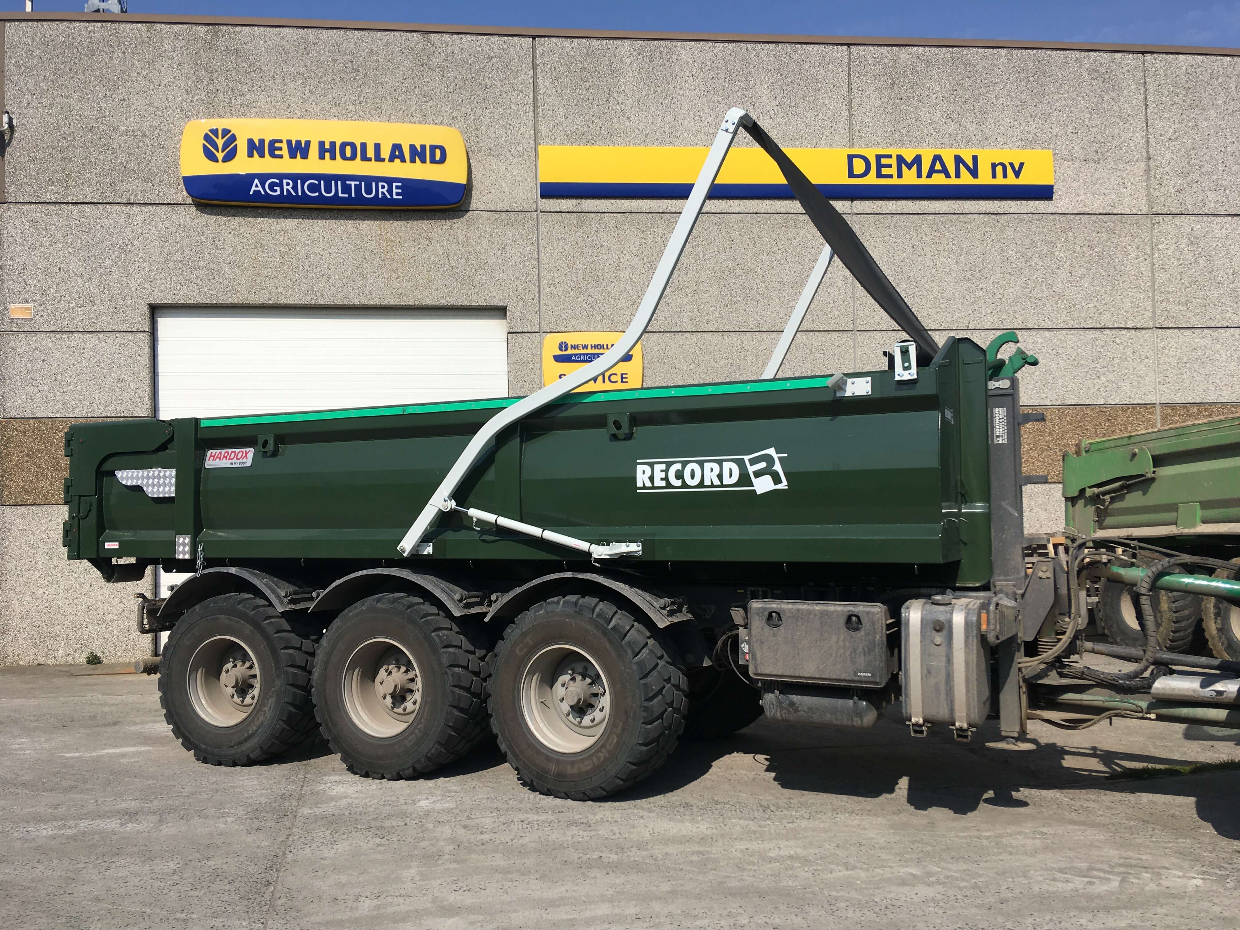 Deman hydraulic arm system puts cover roll over green cargo box